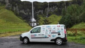 Renault kangoo camper next to a waterfall