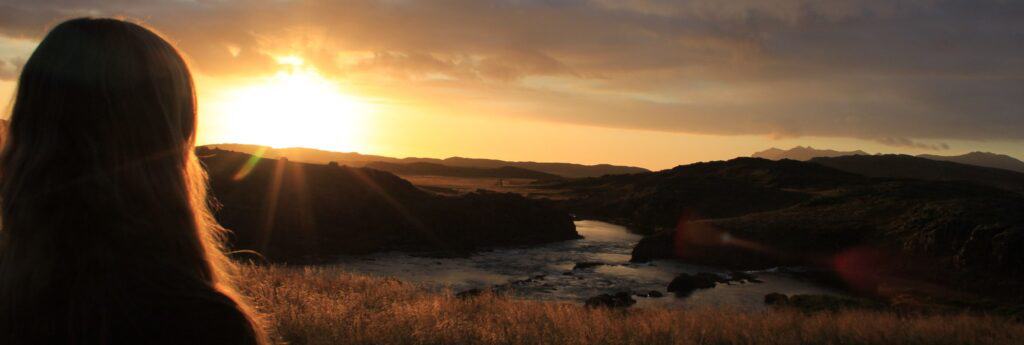 woman looking at sunset over a lake