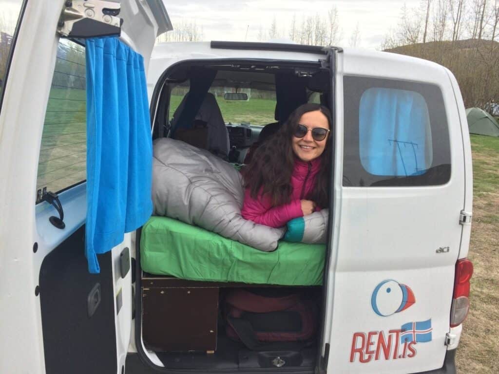 Woman in the back of an open Rent.is camper.