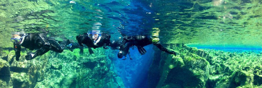 three people snorkeling in Silfra