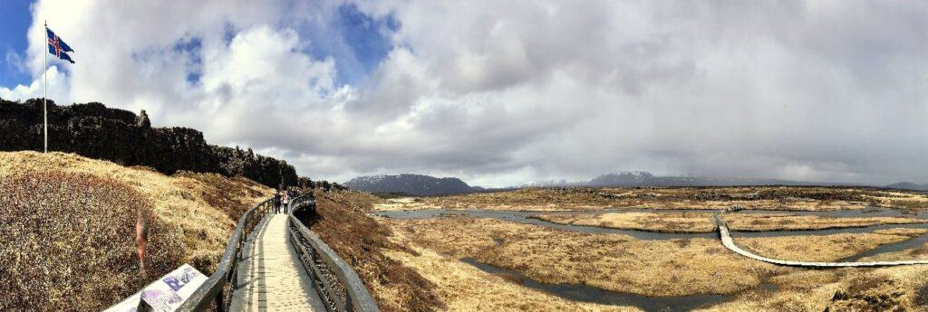 Walking path in þingvellir next to icelandic flag