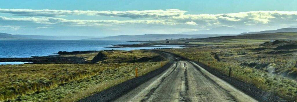 Gravel road in Iceland in a fjord with sea