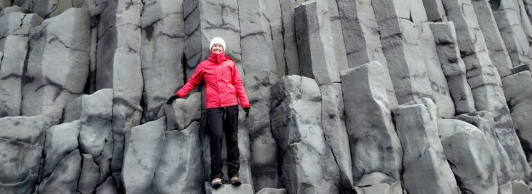 Woman standing on top of columnar basalt in Iceland