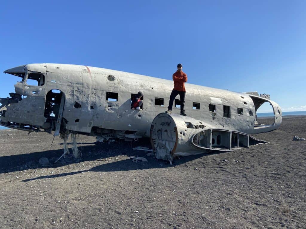 Man and child standing on the sólheimasandur plane wreck