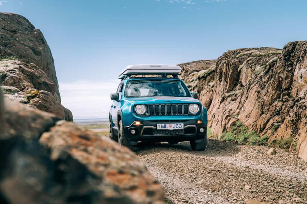 Jeep Renegade camper on gravel road in Iceland in the mountains.