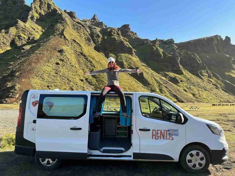 A woman sitting on the roof of a Trafic 3 camper
