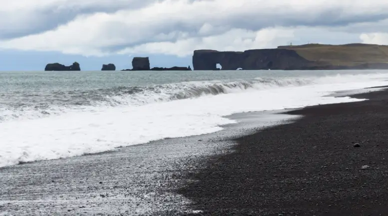 Waves washing onto the black sands of Reynisfjara Beach in Iceland.