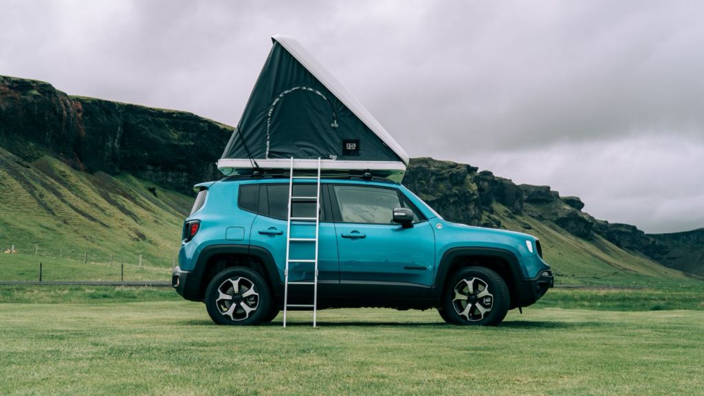 Jeep camper in Iceland with a tent on top.