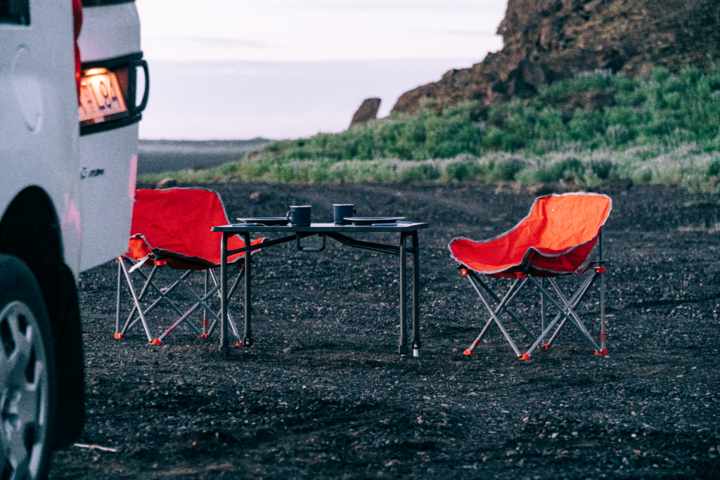 Folding chairs and table outside a campervan in Iceland.