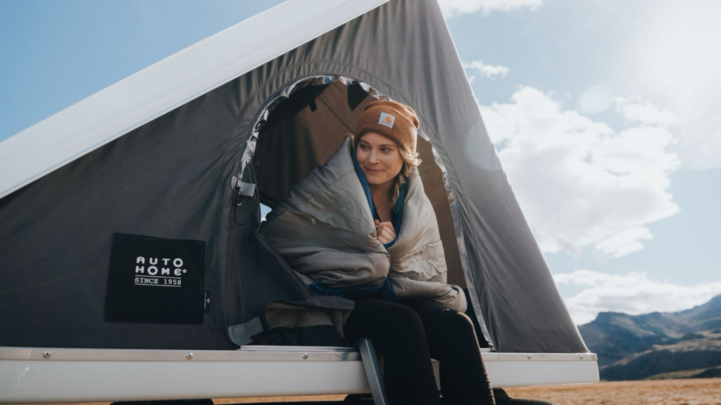 Woman in a rooftop tent in Iceland.