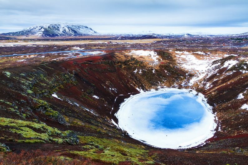 Aerial view of Kerið Crater Lake covered in ice.