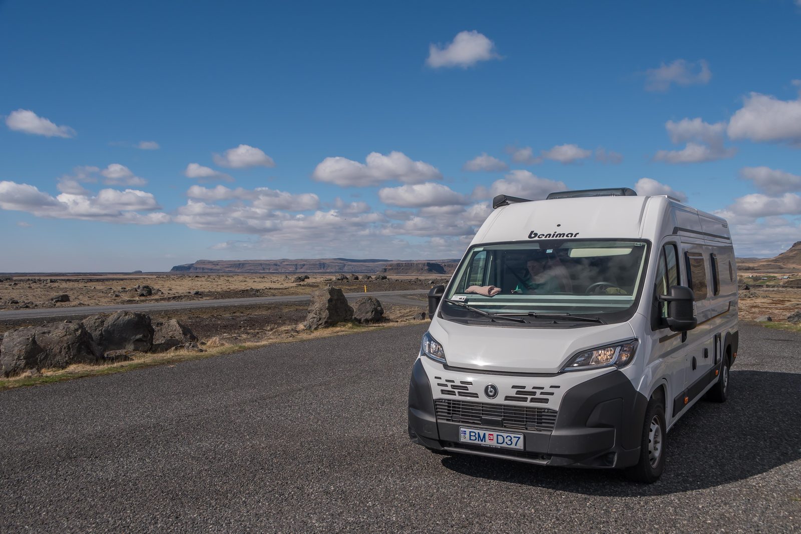 Our campervan parked on a quiet road under blue skies during 7 days in Iceland