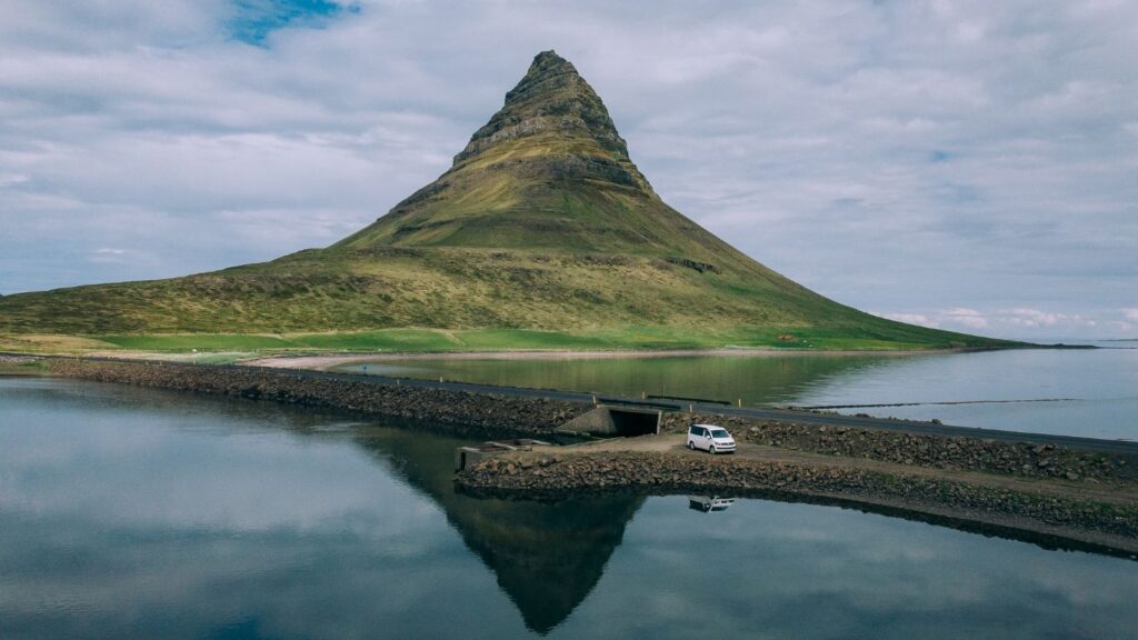 VW California Beach camper in front of Kirkjufell mountain in Iceland