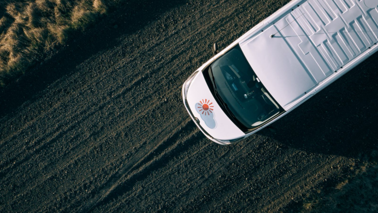Aerial shot of a Renault Trafic driving on a gravel road in Iceland.