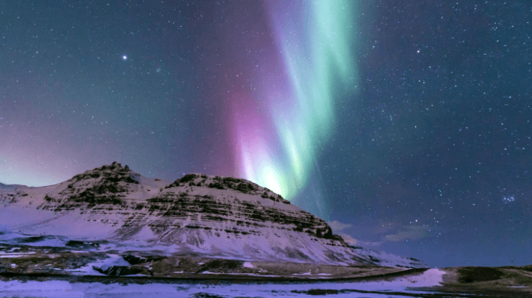 Northern Lights over a snowy mountain in Iceland. 