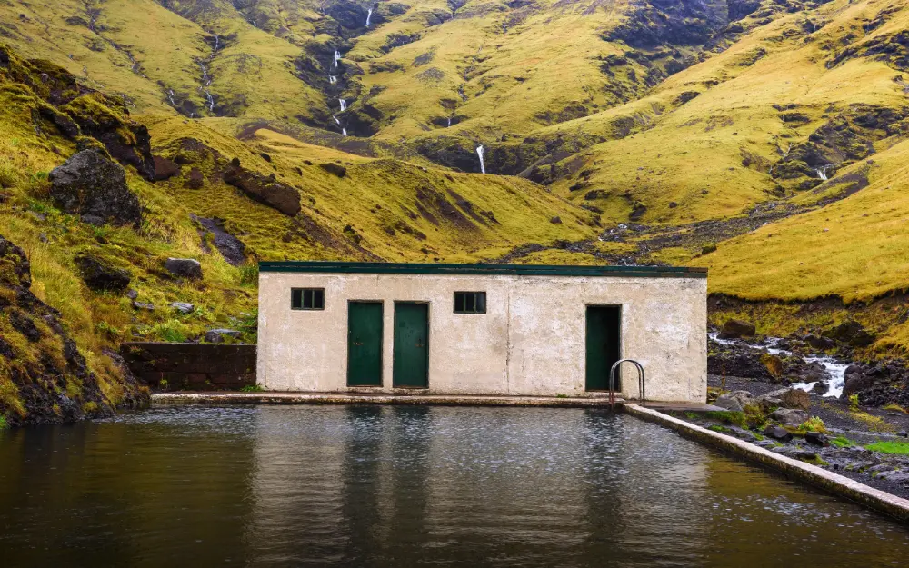 Seljavallalaug outdoor swimming pool nestled in a narrow mountain valley in South Iceland, fed by a natural hot spring