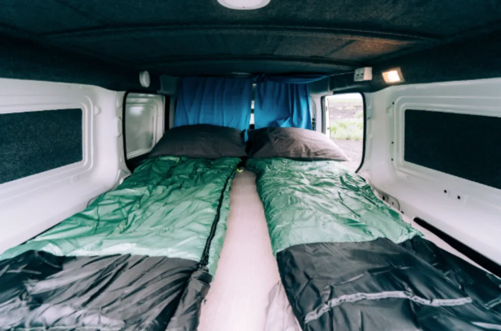 Sleeping bag setup inside a FIAT camper van.