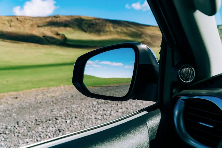 View of Icelandic gravel road and mountainous landscape from the window of a Toyota Hilux