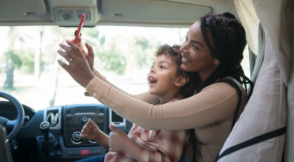 Mother and child taking selfies in a motorhome.