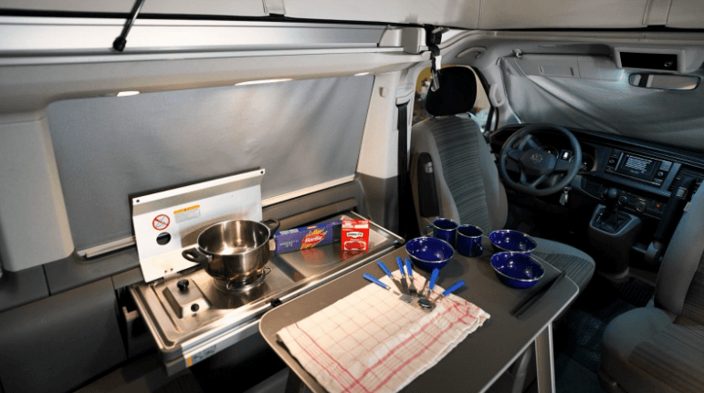 Kitchen setup inside a VW California camper van. 