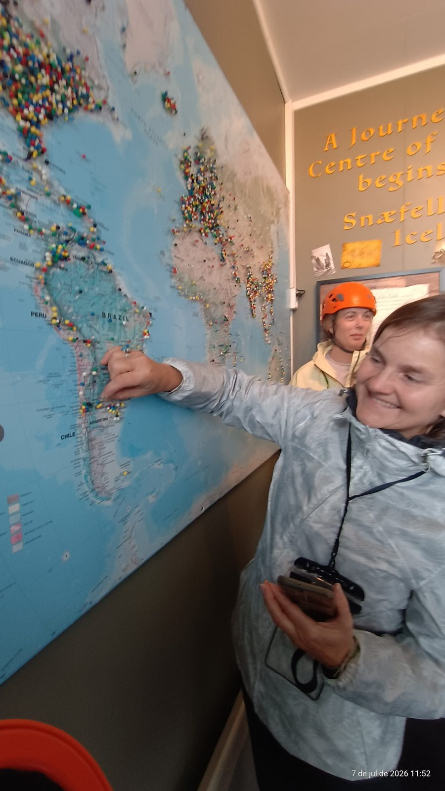Visitor pointing to Argentina on the world map of pins at the Vatnshellir cave entrance