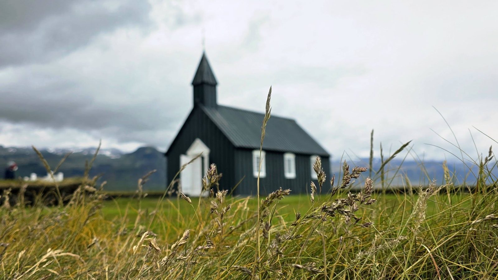 Búðakirkja, the black church at Búðir, surrounded by tall grass on the Snæfellsnes Peninsula