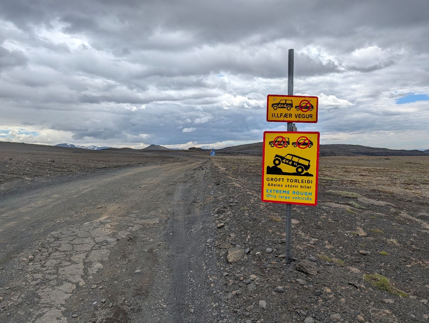 Yellow F-road warning sign reading extreme rough, only large vehicles, beside a gravel track in the Icelandic Highlands