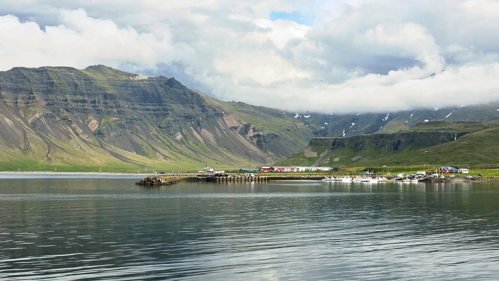 Calm fjord and harbour of Grundarfjörður beneath green mountains on Snæfellsnes