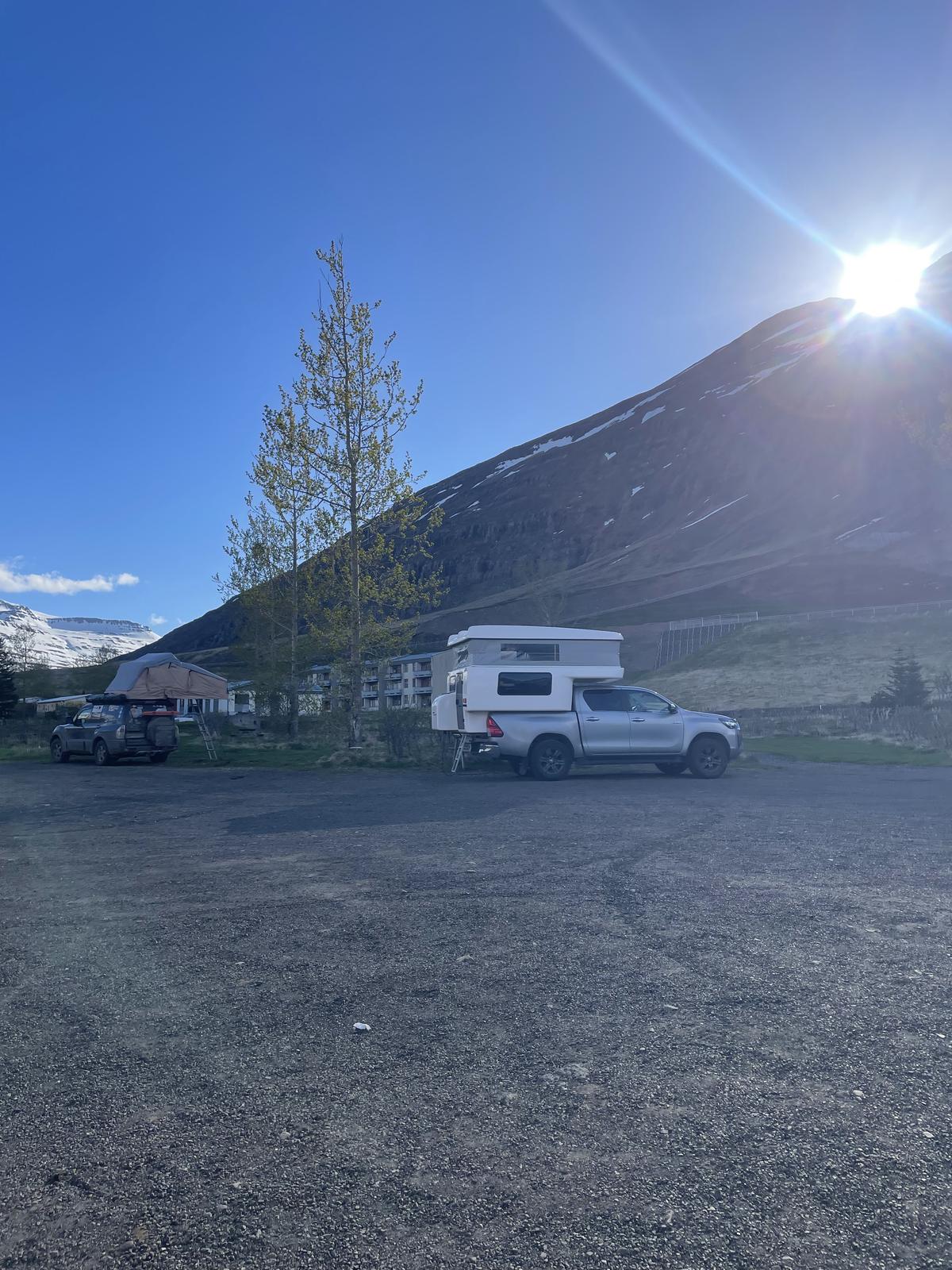 Toyota Hilux camper at the Seyðisfjörður campsite beneath a mountain