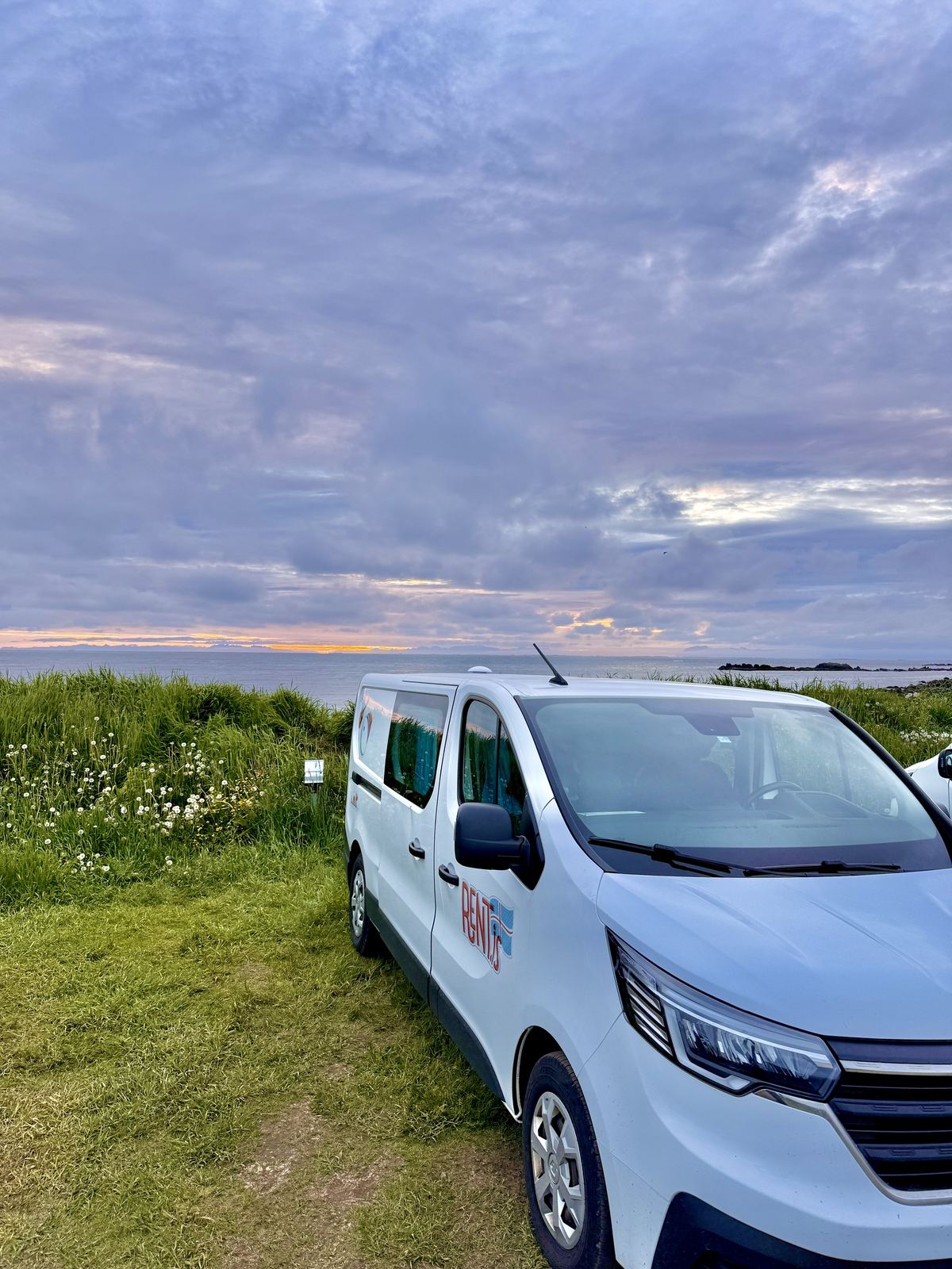 Renault camper van parked on a seaside campsite at dusk in Iceland