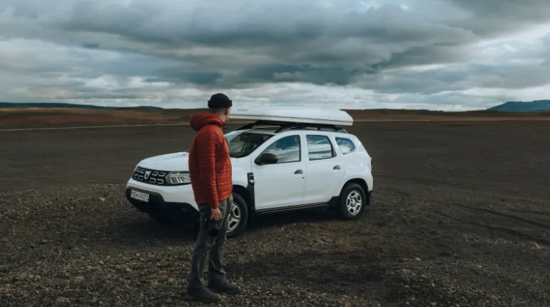 Man standing outside a Dacia Duster 4x4 Roof Top Tent in Iceland.
