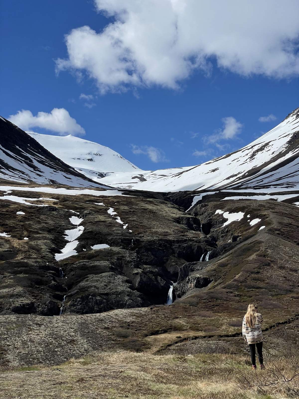 Snow-capped mountains and a waterfall gorge near Reyðarfjörður in the East Fjords