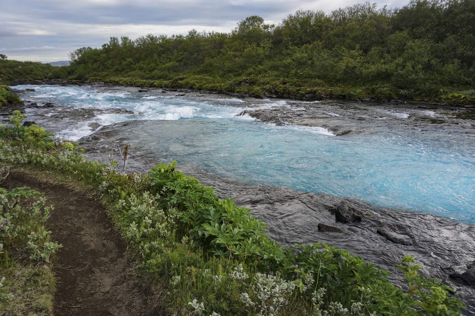 Hiking path beside the turquoise Brúará river on the Golden Circle