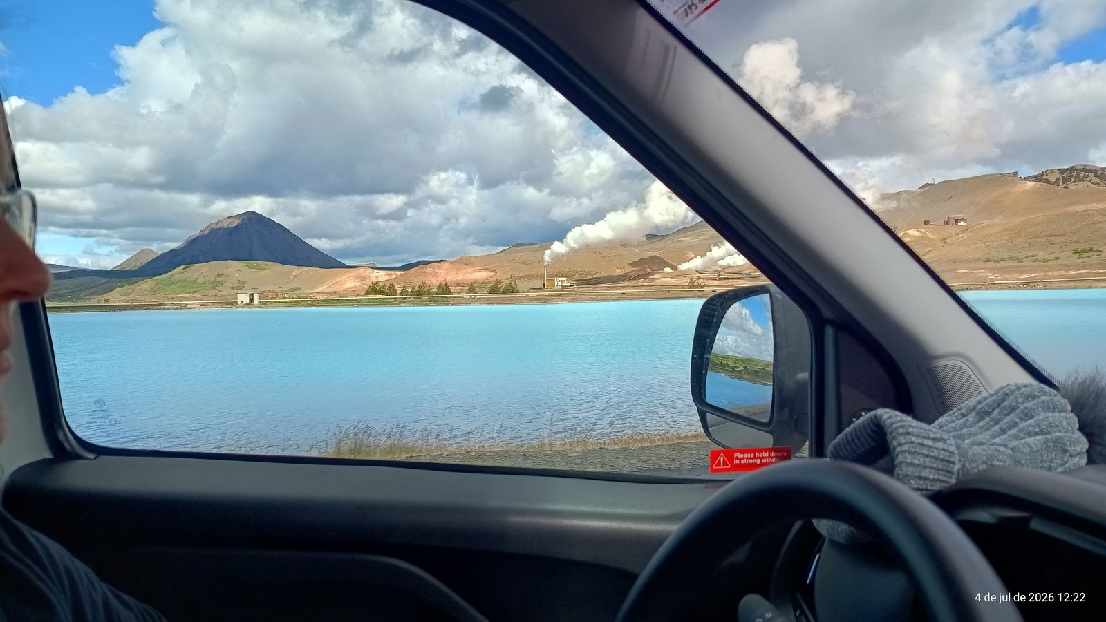 Turquoise geothermal lake and mountains seen through the camper window near Mývatn